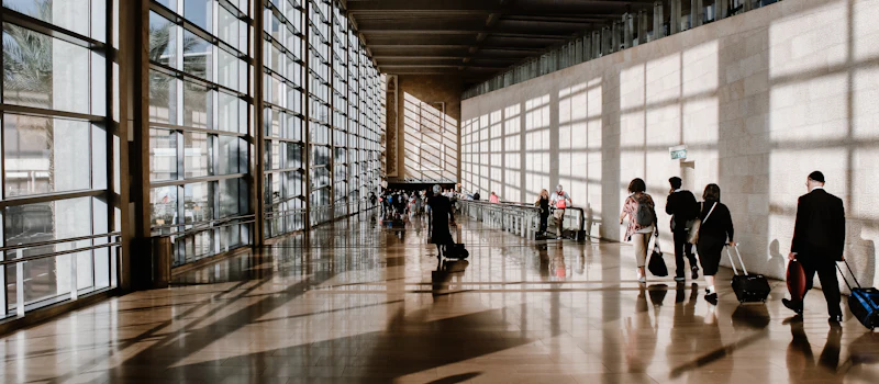 Travellers in a sunlit airport terminal